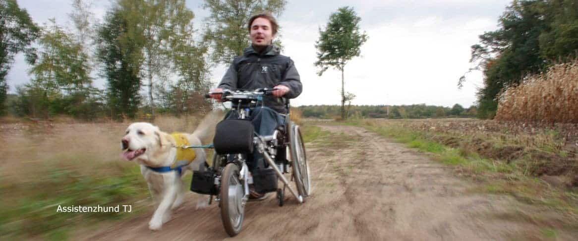 Foto Assistenzhund TJ in Action :: Heller Labrador begleitet ca. 30 Jahre alten eRollifahrer auf beschwingter Fahrt durch die Natur.