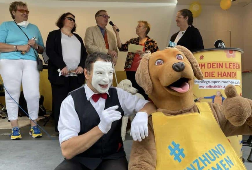 Der SelbsthilfeTruck der Pro Retina lud die Pfotenpiloten ein, die Kampagne "Assistenzhund willkommen" vorzustellen. Benji war natürlich mit an Bord. Auf der Bühne stehen von rechts nach links: Roswitha Warda, die Moderatorin Cornelia Benninghoven, Jörg-Michael Sachse-Schüler, Filomena Muraca-Schwarzer, Heike Ferber.