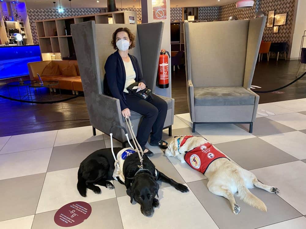 Hannah takes a short break with two assistance dogs at the hotel before the set-up begins.
