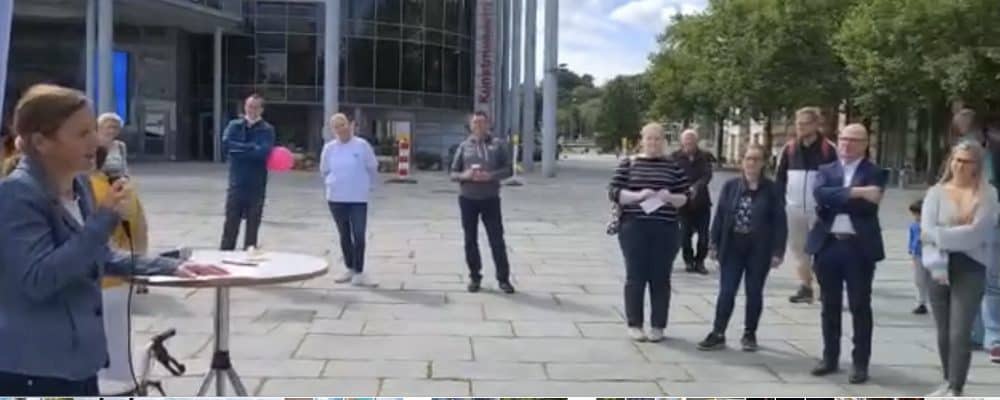 Frau Deimel sieht man hier im weißen T-Shirt  links der Mitte. Am Mikrofon findet Frau Müller, die Sozialdezernentin, klare Worte, was die Akzeptanz und die Zutrittsrechte für Assistenzhund-Teams betrifft.