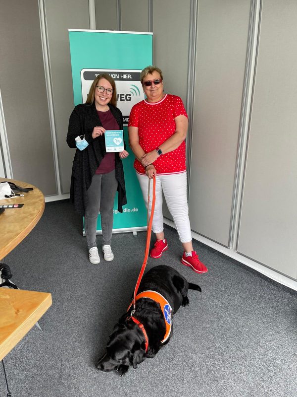 Moderatorin Antonia Grosch vom Hellweg Radio Morgenprogramm und Pfotenpilotin Heike Ferber mit Blindenführhund Anton setzen sich für einen assistenzhundfreundlichen Landkreis Soest ein. 