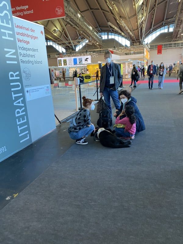 Hannah, Mila, Daika, eine Verlagsmitarbeiterin und Holger besprechen sich auf der Buchmesse.