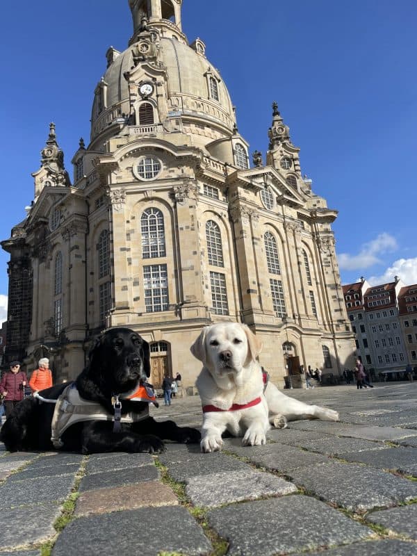 Daika and Mascha are lying on the floor and behind them you can see the Frauenkirche.